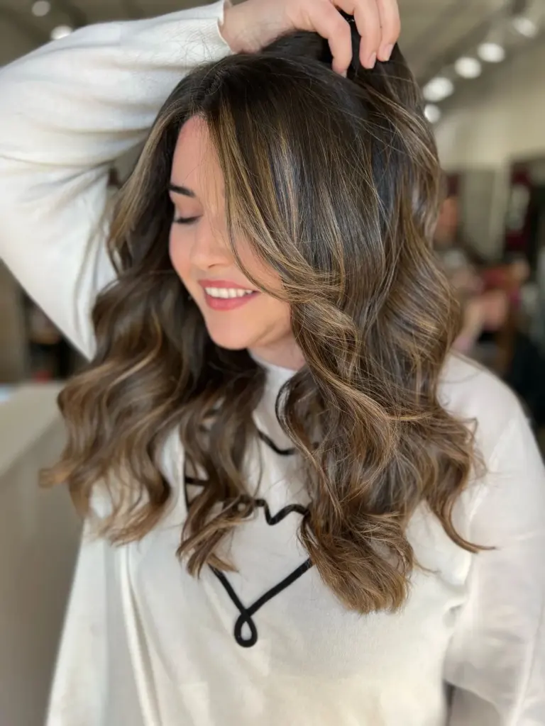 Brunette waves with face-framing caramel highlights