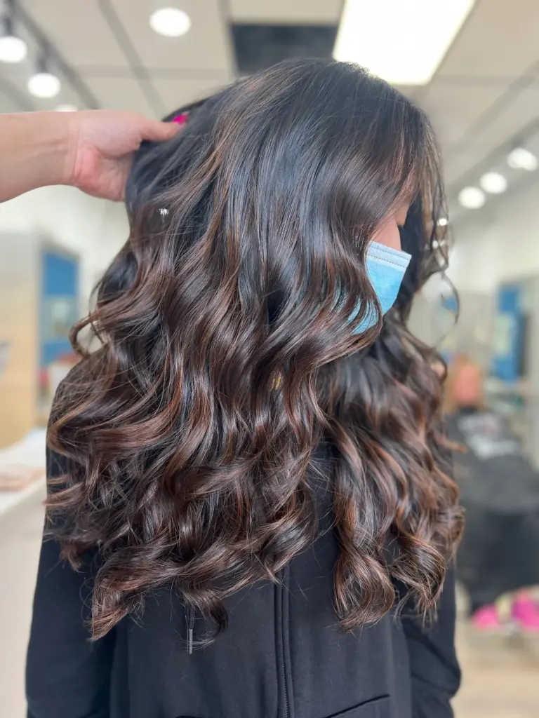 Glossy espresso-brown hair styled in loose, voluminous waves