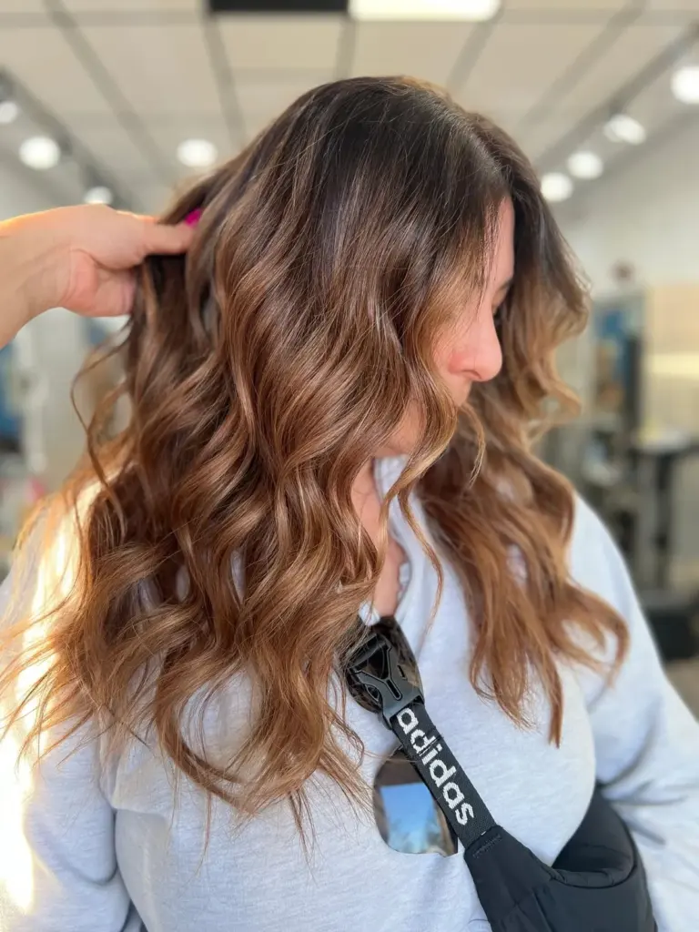 Copper-brown balayage melting into warm, wavy ends