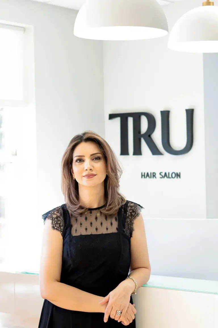 Gina, senior stylist at TRU Salon, standing by the salon reception