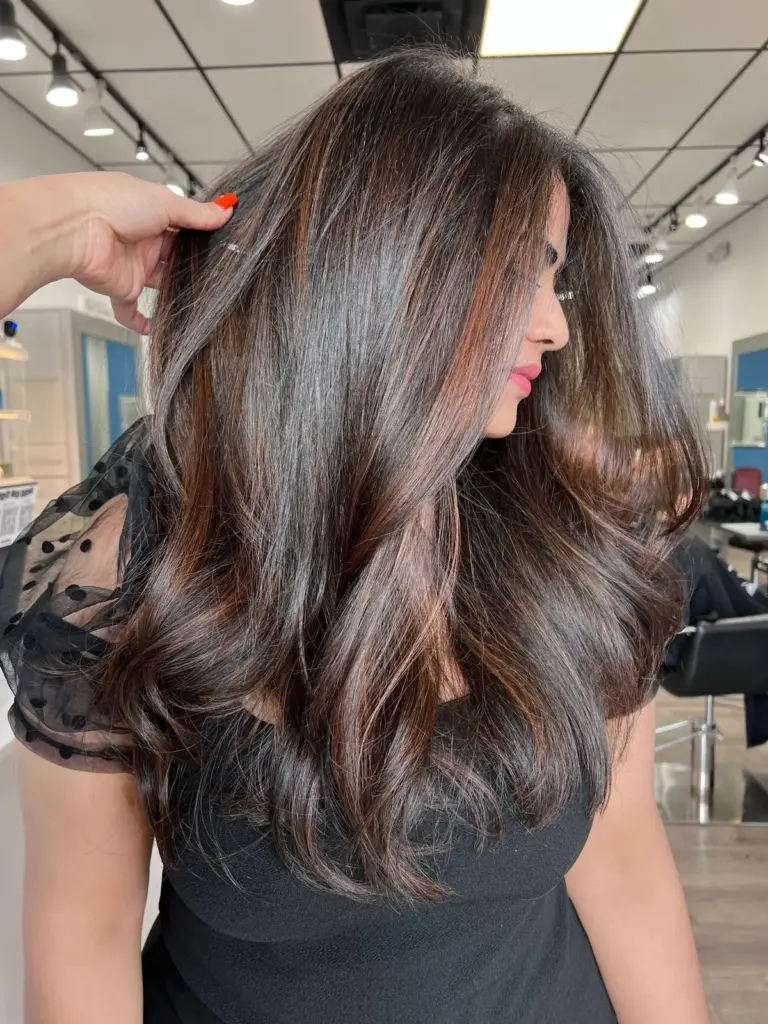 Long, glossy chocolate-brown hair with a smooth blowout finish