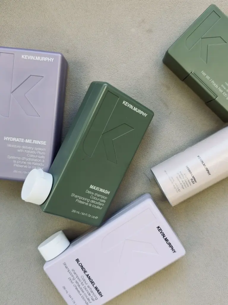 KEVIN.MURPHY hair care bottles, including HYDRATE-ME.RINSE, MAXI.WASH and BLONDE.ANGEL.WASH, on a soft grey surface